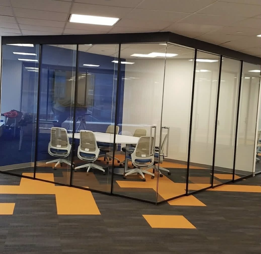 Glass meeting room installed by SOIS with orange accent carpet tiles